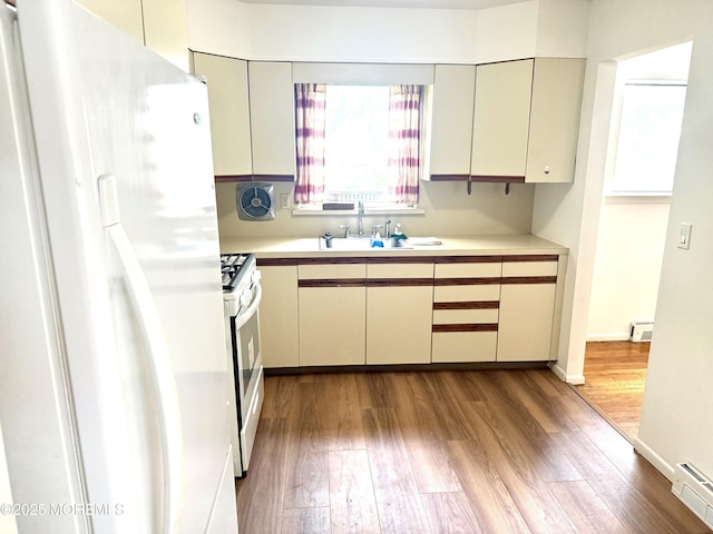 143 Fisher Ave, Brick, NJ 08723 - kitchen with white appliances, light countertops, wood finished floors, and baseboard heating