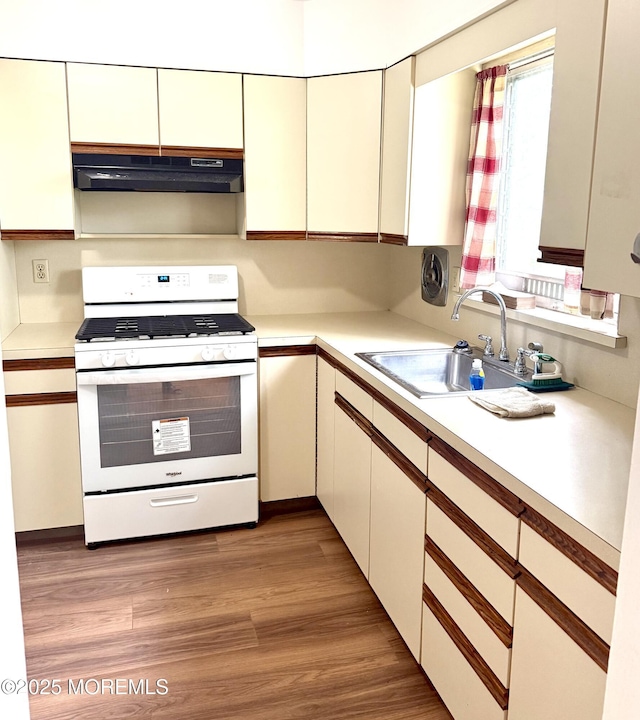 143 Fisher Ave, Brick, NJ 08723 - kitchen with white range with gas stovetop, under cabinet range hood, light countertops, and light wood-style flooring