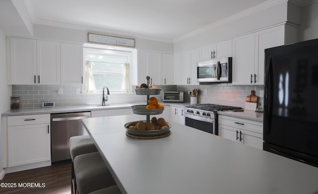 1113 Pemberton St, Toms River, NJ 08757 - kitchen with stainless steel appliances, light countertops, ornamental molding, backsplash, and white cabinetry