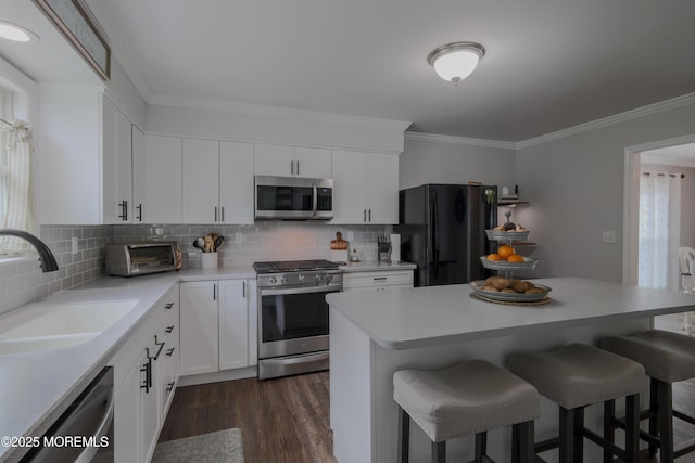 1113 Pemberton St, Toms River, NJ 08757 - kitchen with appliances with stainless steel finishes, a breakfast bar, crown molding, dark wood finished floors, and backsplash