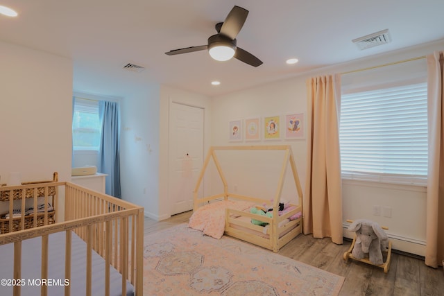 1113 Pemberton St, Toms River, NJ 08757 - bedroom featuring light wood-style floors, a crib, recessed lighting, ceiling fan, and baseboard heating