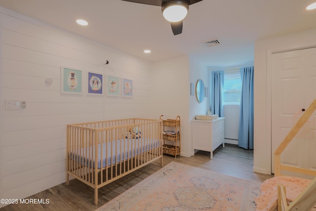 1113 Pemberton St, Toms River, NJ 08757 - bedroom featuring wood finished floors, baseboard heating, ceiling fan, recessed lighting, and a nursery area