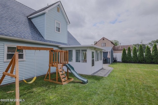 1113 Pemberton St, Toms River, NJ 08757 - rear view of house with a shingled roof, a playground, and a sunroom