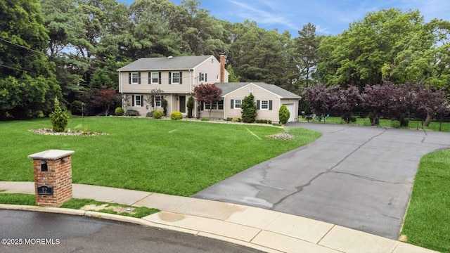 12 Fairway Ave, Eatontown, NJ 07724 - colonial home with driveway, a front lawn, a chimney, and an attached garage