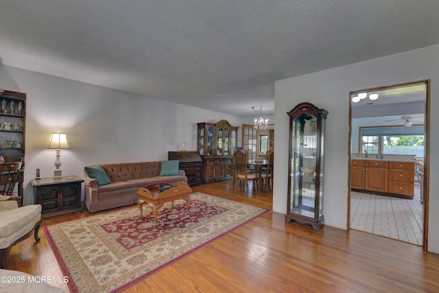 26 Old Manor Rd, Holmdel, NJ 07733 - living area with a chandelier, light wood-style floors, and a textured ceiling