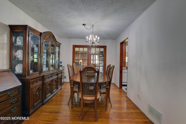26 Old Manor Rd, Holmdel, NJ 07733 - dining space with a chandelier, a textured ceiling, and light wood finished floors
