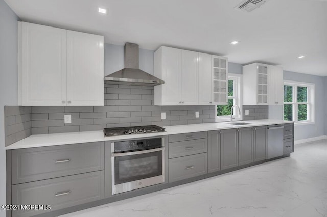 166 Montrose Rd, Colts Neck, NJ 07722 - kitchen with wall chimney exhaust hood, stainless steel appliances, light marble finish floors, gray cabinetry, and decorative backsplash