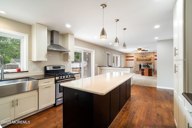 424 Continental St, Forked River, NJ 08731 - kitchen with stainless steel gas range oven, wall chimney exhaust hood, a center island, a ceiling fan, and dark wood-style floors