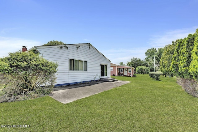 119 Hyannis St, Toms River, NJ 08757 - back of property with a patio area, a yard, and a chimney