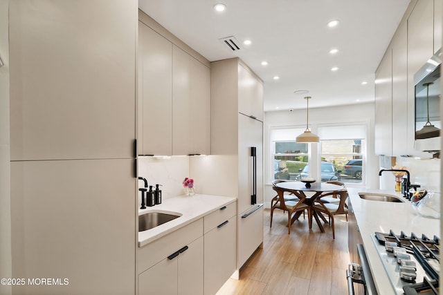 144 Colony Cir, Lakewood, NJ 08701 - kitchen with modern cabinets, recessed lighting, light wood-style floors, hanging light fixtures, and stainless steel gas cooktop