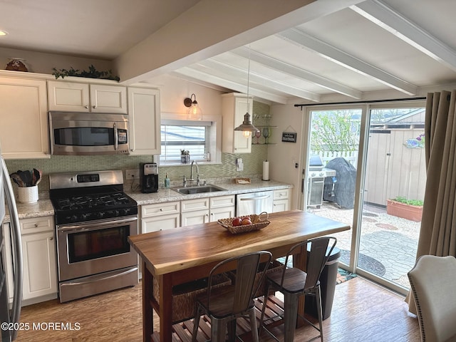 57 Albert Dr, Beach Haven West, NJ 08050 - kitchen with stainless steel appliances, backsplash, light wood finished floors, decorative light fixtures, and light stone countertops