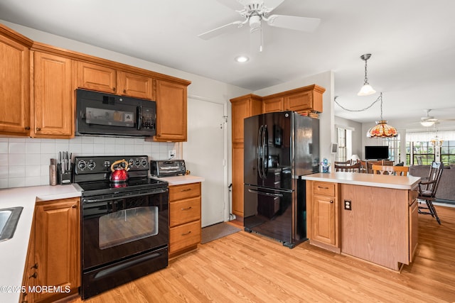 628A Stamford Ct, Manchester, NJ 08759 - kitchen with black appliances, a ceiling fan, light wood-style floors, light countertops, and tasteful backsplash