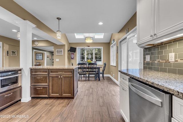 16 Bridge Ct, Jackson, NJ 08527 - kitchen featuring stainless steel appliances, light wood-type flooring, a skylight, tasteful backsplash, and vaulted ceiling