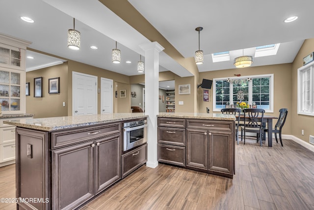 16 Bridge Ct, Jackson, NJ 08527 - kitchen with light wood finished floors, dark brown cabinets, a skylight, light stone countertops, and hanging light fixtures