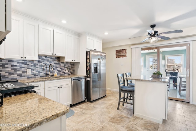 8 S Boston Dr, Little Egg Harbor, NJ 08087 - kitchen with stainless steel appliances, decorative backsplash, white cabinetry, ceiling fan, and light stone countertops