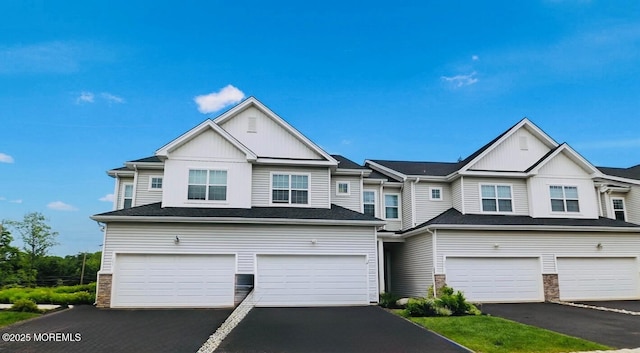 102 Pilot St, Marlboro, NJ 07746 - view of front of house with board and batten siding, an attached garage, driveway, and stone siding