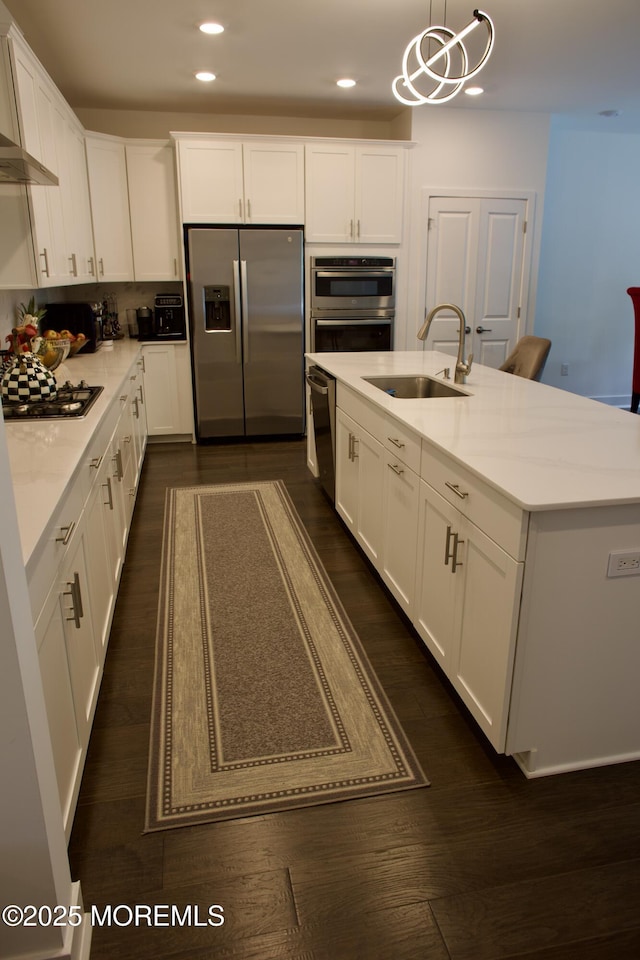 102 Pilot St, Marlboro, NJ 07746 - kitchen featuring appliances with stainless steel finishes, white cabinets, recessed lighting, a kitchen island with sink, and pendant lighting