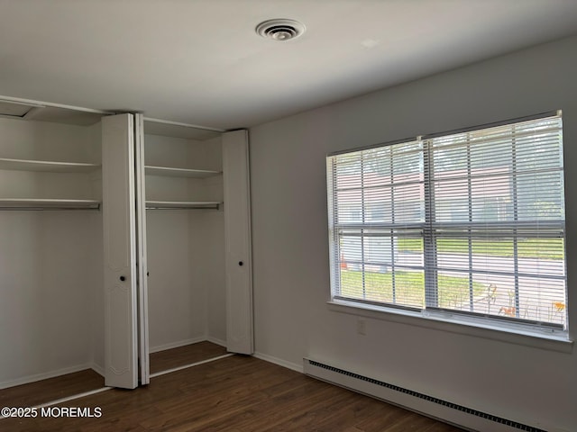 21 Yorkshire Ct Unit A, Manchester, NJ 08759 - unfurnished bedroom with baseboard heating, dark wood-type flooring, and multiple closets