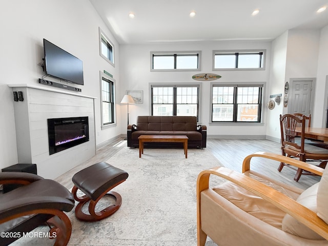 3365 Heron Ln, Lavallette, NJ 08735 - living area featuring a towering ceiling, a glass covered fireplace, light wood-type flooring, and recessed lighting