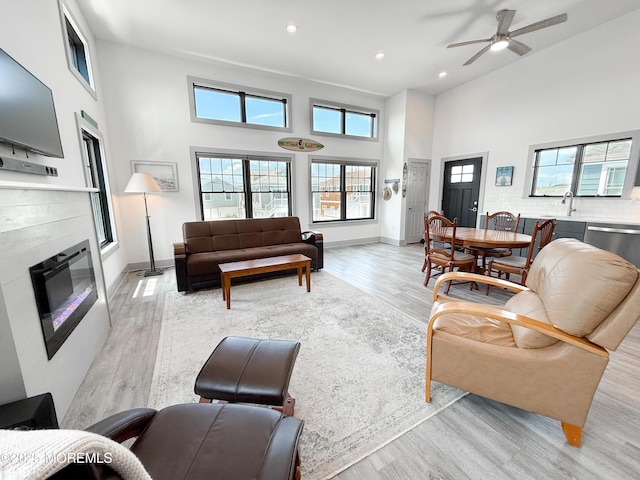 3365 Heron Ln, Lavallette, NJ 08735 - living room featuring a high ceiling, light wood-style floors, recessed lighting, a glass covered fireplace, and ceiling fan
