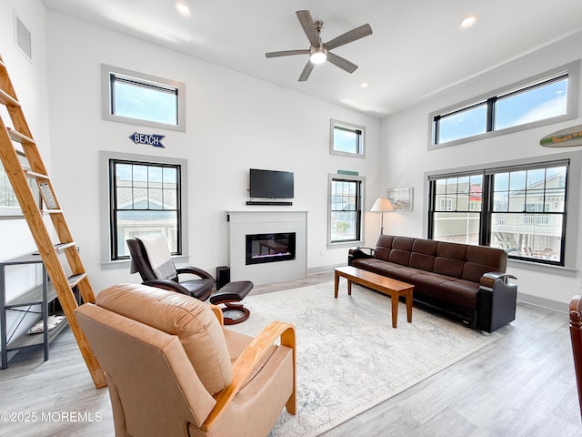 3365 Heron Ln, Lavallette, NJ 08735 - living area featuring a glass covered fireplace, light wood finished floors, a high ceiling, ceiling fan, and recessed lighting