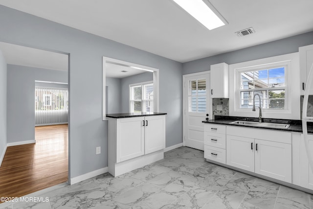 292 Washington Rd, Sayreville, NJ 08872 - kitchen featuring light marble finish floors, dark countertops, white cabinetry, and decorative backsplash