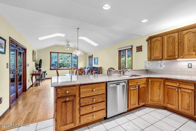 53 Edison Ave, Tinton Falls, NJ 07724 - kitchen with stainless steel dishwasher, a skylight, a peninsula, brown cabinets, and lofted ceiling