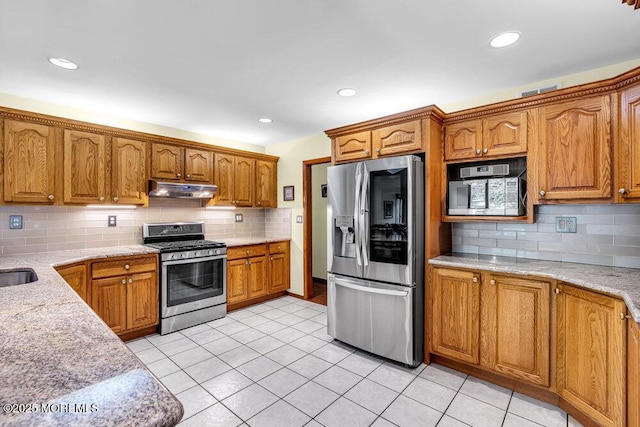 53 Edison Ave, Tinton Falls, NJ 07724 - kitchen with appliances with stainless steel finishes, under cabinet range hood, backsplash, brown cabinetry, and recessed lighting