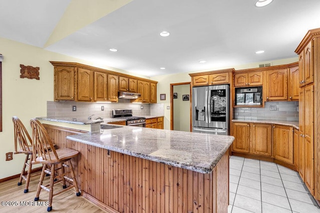 53 Edison Ave, Tinton Falls, NJ 07724 - kitchen featuring appliances with stainless steel finishes, a peninsula, tasteful backsplash, brown cabinetry, and recessed lighting