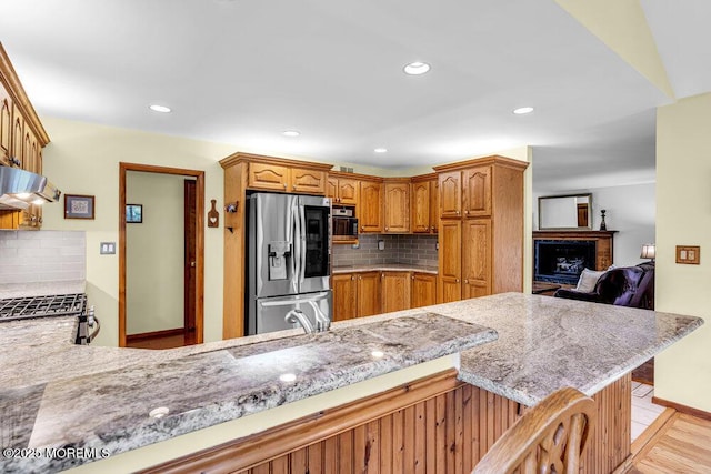 53 Edison Ave, Tinton Falls, NJ 07724 - kitchen with appliances with stainless steel finishes, decorative backsplash, ventilation hood, light stone countertops, and recessed lighting