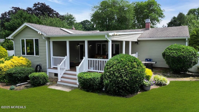 53 Edison Ave, Tinton Falls, NJ 07724 - view of front facade featuring a chimney, a front yard, a shingled roof, and covered porch