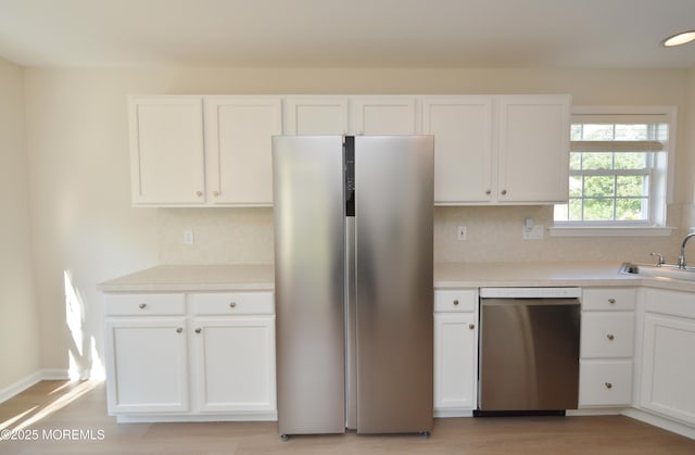 3229 Flagstone Ct, Toms River, NJ 08755 - kitchen with appliances with stainless steel finishes, light wood finished floors, white cabinets, light countertops, and tasteful backsplash