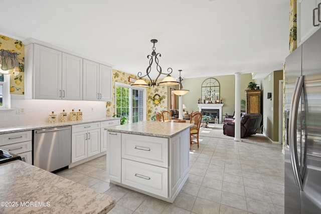 21 Orchid Ln, Barnegat, NJ 08005 - kitchen with stainless steel appliances, light tile patterned flooring, tasteful backsplash, white cabinets, and decorative light fixtures