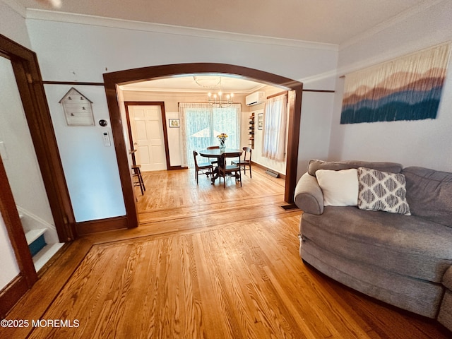 357 Boland Ave, Brick, NJ 08724 - living area with arched walkways, crown molding, light wood-style floors, a chandelier, and an AC wall unit