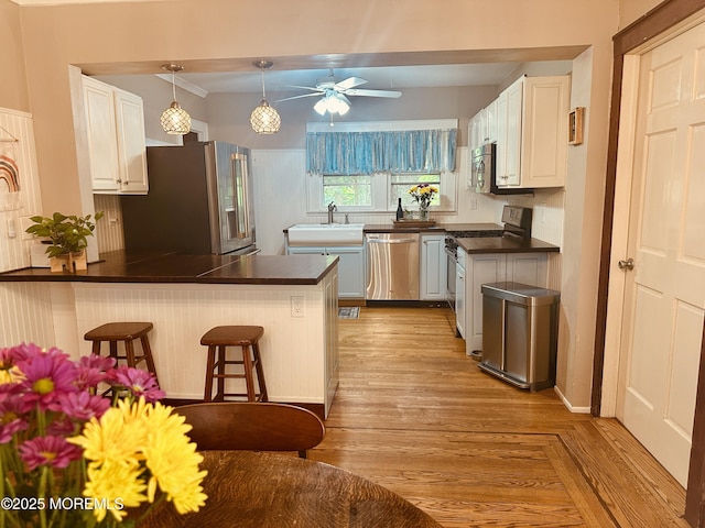357 Boland Ave, Brick, NJ 08724 - kitchen featuring stainless steel appliances, dark countertops, a peninsula, ceiling fan, and a breakfast bar area