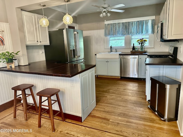 357 Boland Ave, Brick, NJ 08724 - kitchen with appliances with stainless steel finishes, a peninsula, light wood finished floors, white cabinets, and a breakfast bar area
