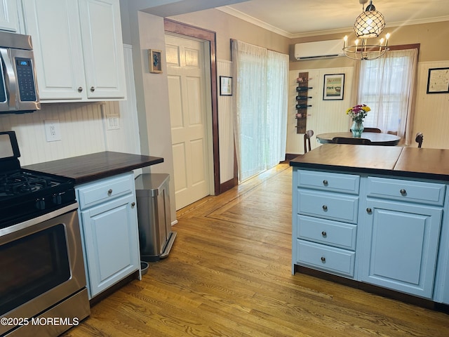 357 Boland Ave, Brick, NJ 08724 - kitchen featuring appliances with stainless steel finishes, blue cabinetry, a chandelier, a wall mounted air conditioner, and crown molding