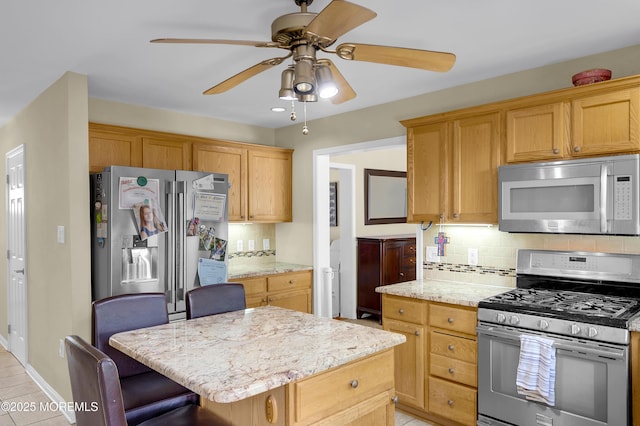315 Shuster Ave, Ortley Beach, NJ 08751 - kitchen with appliances with stainless steel finishes, backsplash, a ceiling fan, a kitchen island, and a kitchen bar