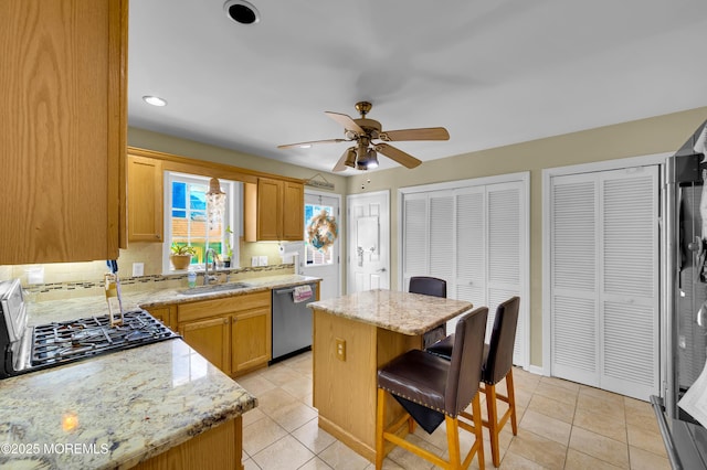 315 Shuster Ave, Ortley Beach, NJ 08751 - kitchen featuring dishwasher, ceiling fan, a center island, a breakfast bar, and light stone countertops