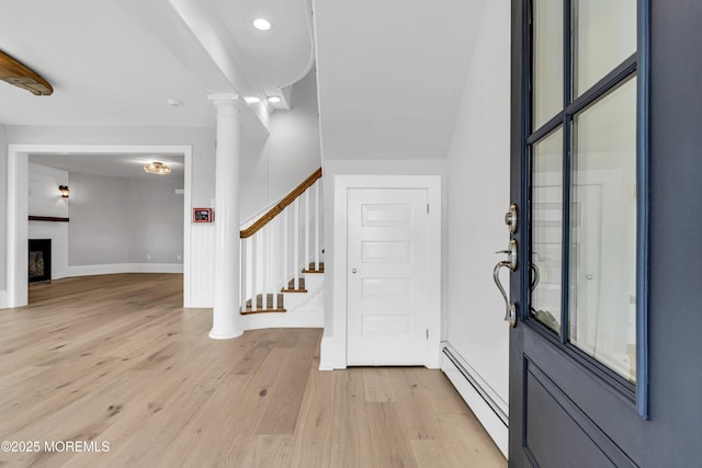900 Ocean Ave, Bradley Beach, NJ 07720 - entrance foyer featuring baseboard heating, light wood finished floors, stairway, a fireplace, and ornate columns