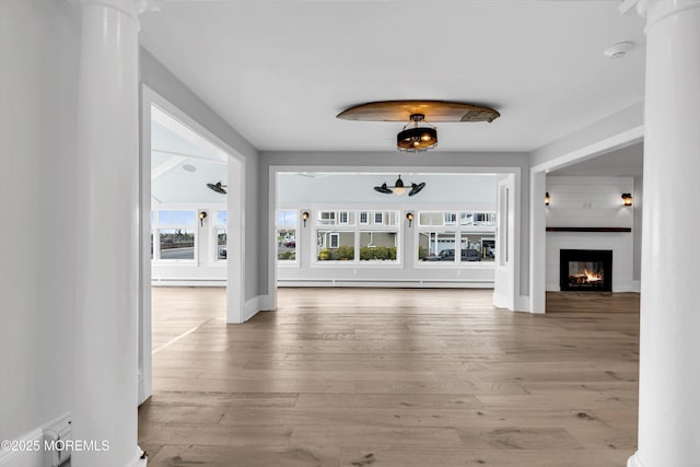 900 Ocean Ave, Bradley Beach, NJ 07720 - unfurnished living room featuring ornate columns, a baseboard radiator, and wood finished floors