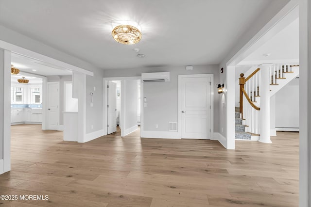 900 Ocean Ave, Bradley Beach, NJ 07720 - empty room with stairs, a wall mounted AC, light wood finished floors, and baseboard heating