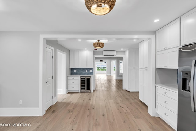 900 Ocean Ave, Bradley Beach, NJ 07720 - kitchen with wine cooler, stainless steel fridge with ice dispenser, an AC wall unit, light wood finished floors, and recessed lighting