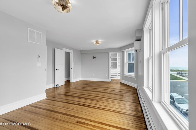 900 Ocean Ave, Bradley Beach, NJ 07720 - unfurnished room featuring a wall mounted air conditioner, wood finished floors, and a baseboard heating unit