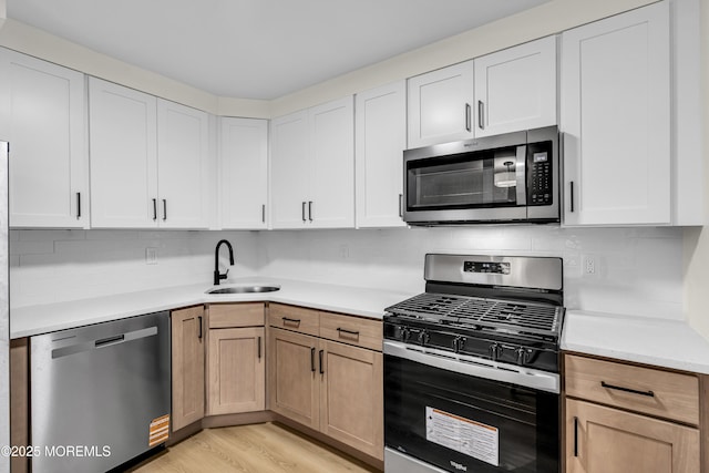 104 Dundee Ct, Aberdeen, NJ 07747 - kitchen featuring appliances with stainless steel finishes, light countertops, light wood-style flooring, decorative backsplash, and white cabinetry
