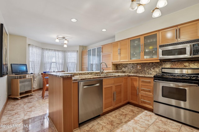 149 Jefferson Dr, Ocean Twp, NJ 07712 - kitchen with appliances with stainless steel finishes, a peninsula, stone countertops, tasteful backsplash, and glass insert cabinets