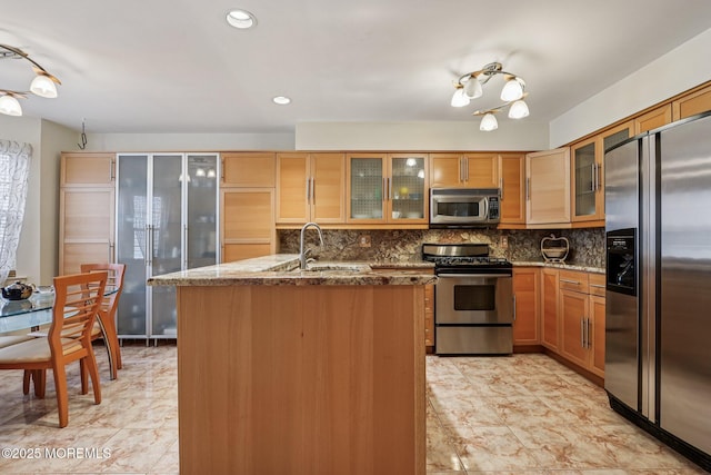 149 Jefferson Dr, Ocean Twp, NJ 07712 - kitchen with stainless steel appliances, tasteful backsplash, dark stone countertops, an island with sink, and glass insert cabinets