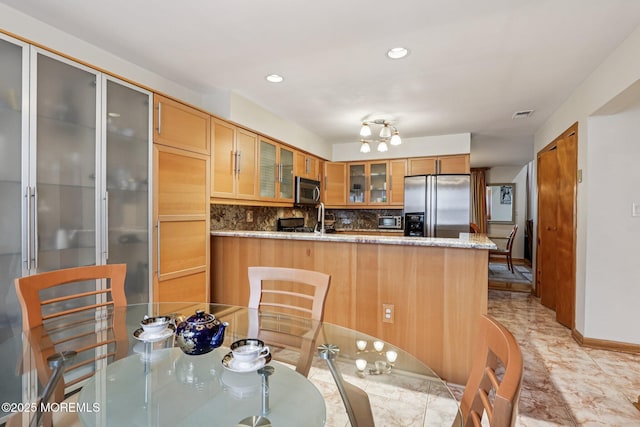 149 Jefferson Dr, Ocean Twp, NJ 07712 - kitchen with appliances with stainless steel finishes, a peninsula, glass insert cabinets, decorative backsplash, and stone counters