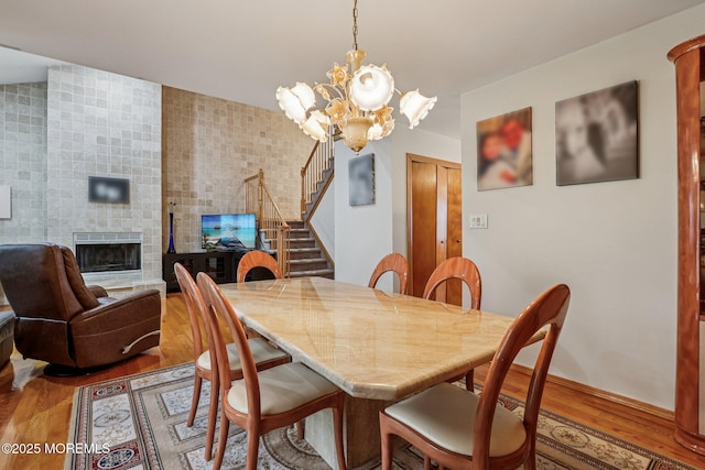 149 Jefferson Dr, Ocean Twp, NJ 07712 - dining room with wood finished floors, stairway, a chandelier, and a large fireplace