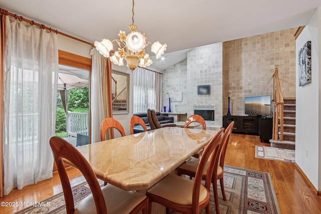 149 Jefferson Dr, Ocean Twp, NJ 07712 - dining space featuring stairway, a chandelier, a fireplace, lofted ceiling, and wood finished floors
